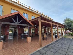 a covered patio with tables and chairs in front of a building at Hotel venta de Tébar in Águilas
