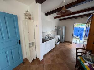 a kitchen with white cabinets and a blue door at Villa Maria Citara Beach in Forio d'Ischia