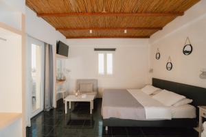 a bedroom with a large bed and a table at Skala Sunset Hotel and spa in Ios Chora +40 photos
