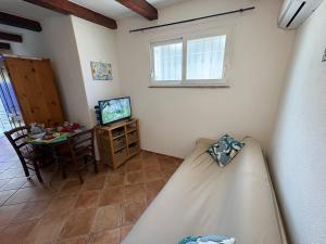 a room with a bed and a table and a television at Villa Maria Citara Beach in Forio d'Ischia