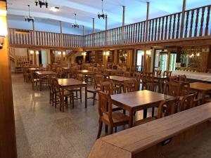 an empty restaurant with wooden tables and chairs at Hotel HAVLOV in Žďárec