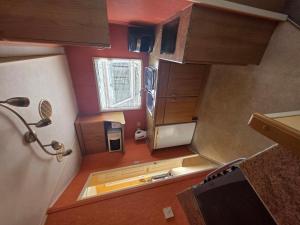 an overhead view of a small kitchen with wooden cabinets at Twin Ayre Cabin Retreat Welshpool in Welshpool