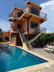 a villa with a swimming pool in front of a house at Casitas Las Palmas - Brisa Marina in Punta Mita