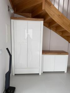 a room with a white cabinet and a staircase at MazuryLive in Węgorzewo