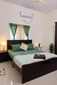 a bedroom with a large bed with green sheets at Deccan Homes Kondapur in Hyderabad