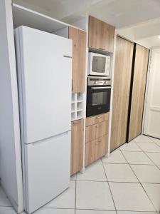 a kitchen with a refrigerator and a microwave at maison cosy pour 4 à 5 personnes 10mns des plages in Sanary-sur-Mer