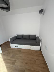 a couch in a room with a white wall at MazuryLive in Węgorzewo