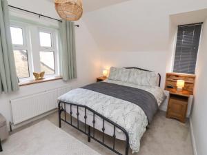 a bedroom with a bed and two windows at The Lodge in Alnwick