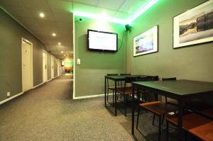 a room with tables and a tv on the wall at Grad Hotel and Hostel in Stockholm