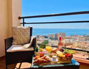 a table with food and drinks and a view of the city at Espacioso Dúplex con terraza y vistas in Aguadulce
