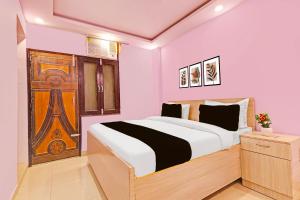 a bedroom with a bed and a wooden door at Hotel O Sky House Residency in New Delhi