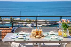 a table on a balcony with a view of the ocean at Portopiccolo Apartments in Sistiana +48 photos