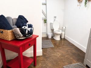 a bathroom with a red table and a toilet at Carriage House in Lufkin +22 photos