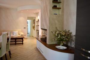 a living room with a fireplace and a table with flowers at Il marchese Malaspina con idromassaggio in Mulazzo