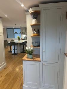 a kitchen with white cabinets and a dining room at Ladywell Barn in Threshfield