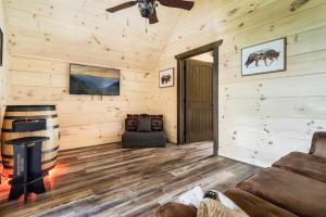 a living room with a ceiling fan and wooden walls at Paradise Point in Pigeon Forge