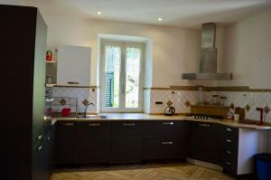 a kitchen with brown cabinets and a window in it at Il marchese Malaspina con idromassaggio in Mulazzo