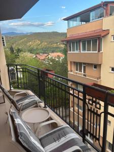a balcony with chairs and tables on a building at Apartament Emi in Sandanski