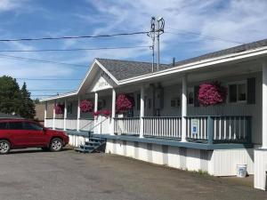 a house with a red car parked in front of it at Martin's Motel USA in Madawaska