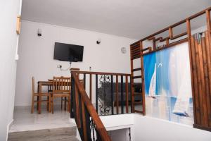 a living room with a staircase and a tv and a table at Cadets Studio in Mahébourg
