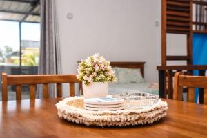 a table with a vase of flowers and plates on it at Cadets Studio in Mahébourg
