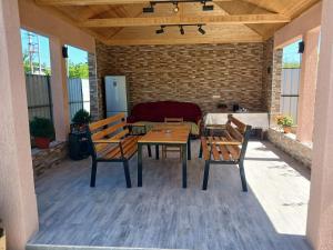 a patio with two wooden benches and a table at Guest house Nano in Martvili