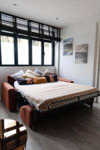 a large bed in a room with windows at Le Petit Brooklyn, 2 chambres 2 sdb, cœur de Strasbourg in Strasbourg