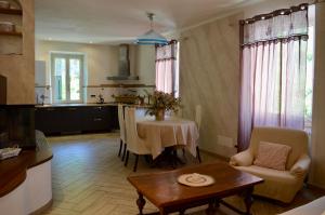 a living room with a table and a kitchen at Il marchese Malaspina con idromassaggio in Mulazzo