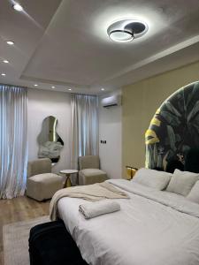a bedroom with a large bed and two chairs at Vluxuries in Lekki