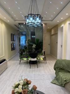 a living room with a dining table and a chandelier at Vluxuries in Lekki