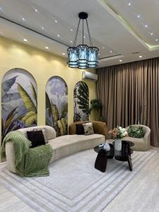 a living room with two couches and a chandelier at Vluxuries in Lekki