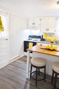 a kitchen with white cabinets and a table and stools at Cozy Mountain Rancher in Harpers Ferry +11 photos