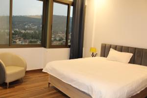 a bedroom with a bed and a chair and windows at two seasons hotel in Bangui