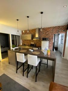 a kitchen with a wooden table and white chairs at Le Petit Brooklyn, 2 chambres 2 sdb, cœur de Strasbourg in Strasbourg