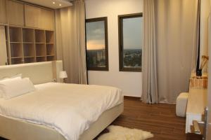 a bedroom with a white bed and two windows at two seasons hotel in Bangui +85 photos