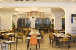 a restaurant with tables and chairs and a chandelier at two seasons hotel in Bangui