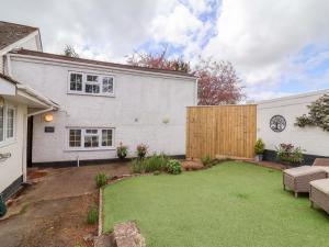 a backyard of a white house with a lawn at The Apple Loft in Exeter
