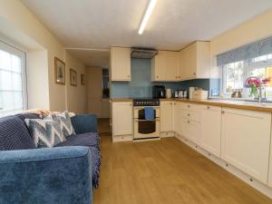 a living room with a couch and a kitchen at The Apple Loft in Exeter