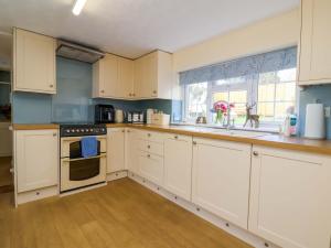 a kitchen with white cabinets and a sink and a window at The Apple Loft in Exeter +18 photos