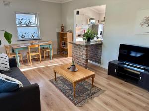 a living room with a couch and a coffee table at Spacious cottage with a private garden in Somerset West