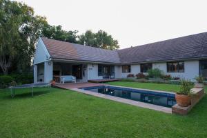 a house with a swimming pool in the yard at Spacious cottage with a private garden in Somerset West