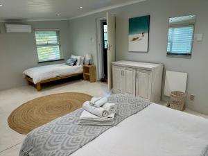 a bedroom with a bed with towels on it at Spacious cottage with a private garden in Somerset West +16 photos
