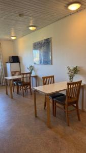 a room with a table and chairs and a refrigerator at Hine Bakke Bed And Breakfast in Rudkøbing