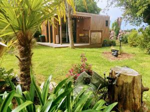 a house in a yard with trees and plants at le petit gîte de mag in Plouha