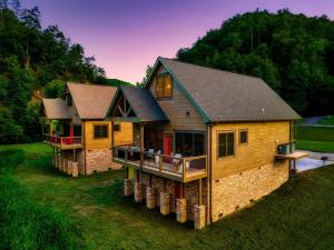 a large wooden house with a porch on a lawn at Paradise Point in Pigeon Forge