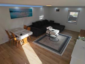 a living room with a black couch and a table at Ferienwohnung ERSO in Wutöschingen
