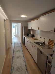 a kitchen with white cabinets and a sink at Ferienwohnung ERSO in Wutöschingen