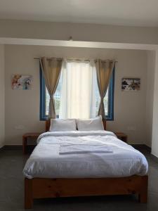 a large bed in a bedroom with a window at E-RE House, Dirang in Dirang Dzong +8 photos