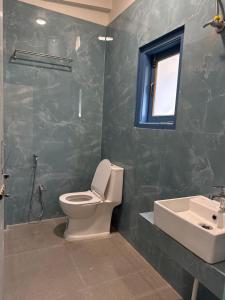 a bathroom with a toilet and a sink and a window at E-RE House, Dirang in Dirang Dzong