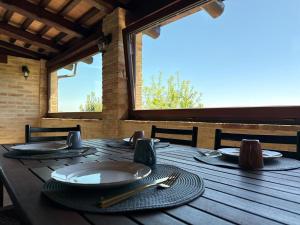 a wooden table with plates and utensils on it at Prana Hill in Cupramontana